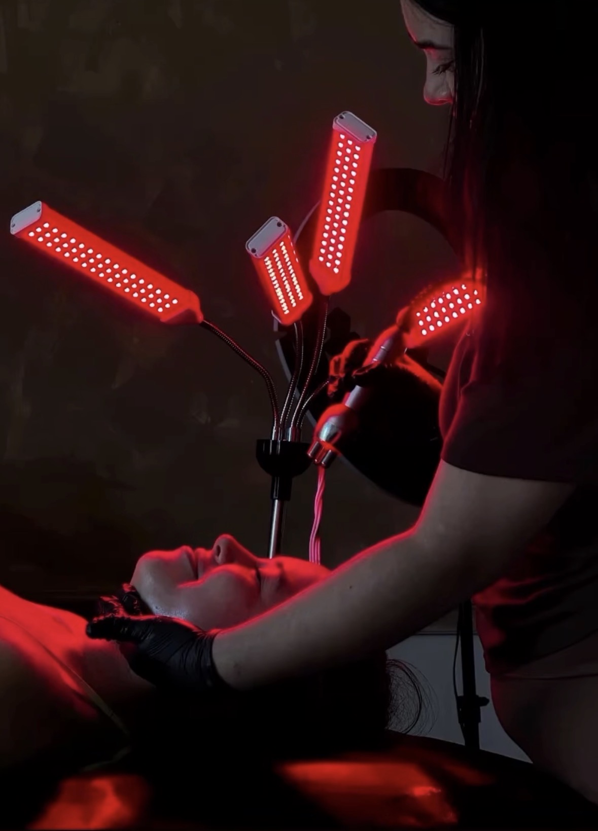 Esthetician performing an LED red light therapy facial treatment at The Beautology Shop in Houston, TX